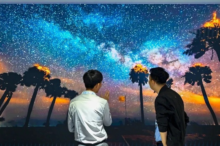 長(zhǎng)春光博會(huì)希達(dá)電子展區(qū)，一位工作人員正在給一位觀眾講解。（長(zhǎng)春新區(qū)供圖）