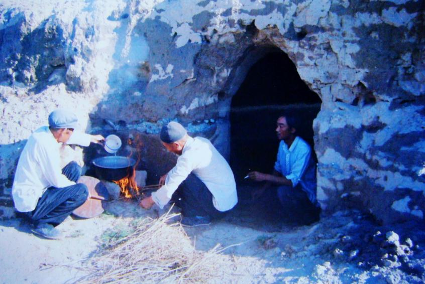1983年，“六老漢”一代治沙人在“地窩子”生活做飯。新華社發(fā)（八步沙林場(chǎng)供圖）