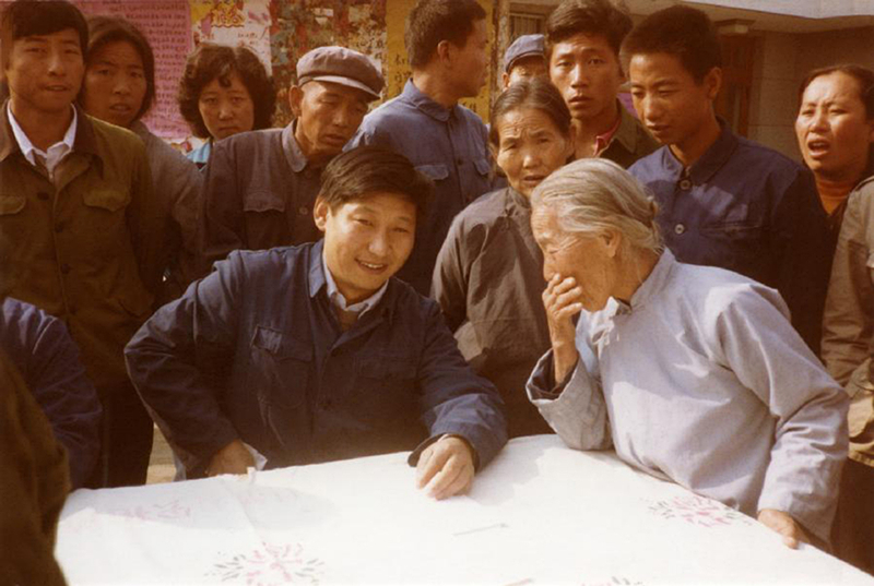 1983年，時(shí)任河北正定縣委書記的習(xí)近平（前排居中），臨時(shí)在大街上擺桌子聽取老百姓意見。