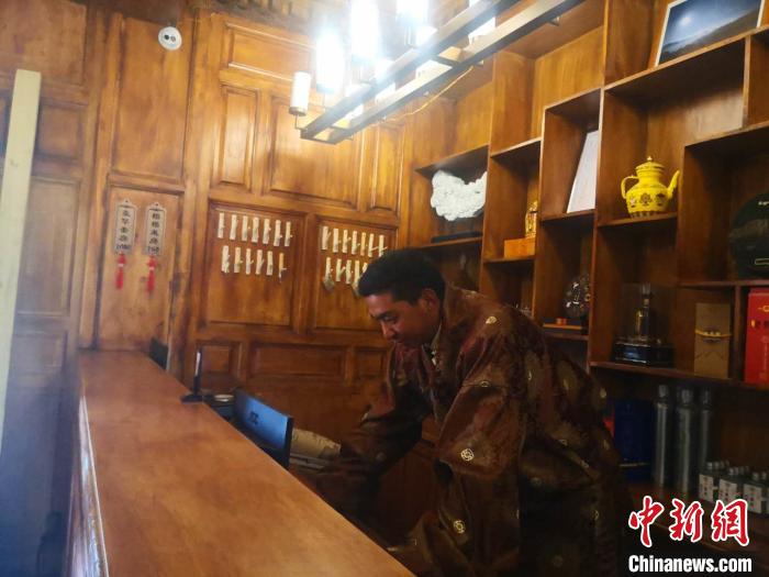 圖為桑杰才讓用電腦處理財(cái)務(wù)?！∈缝o靜 攝
