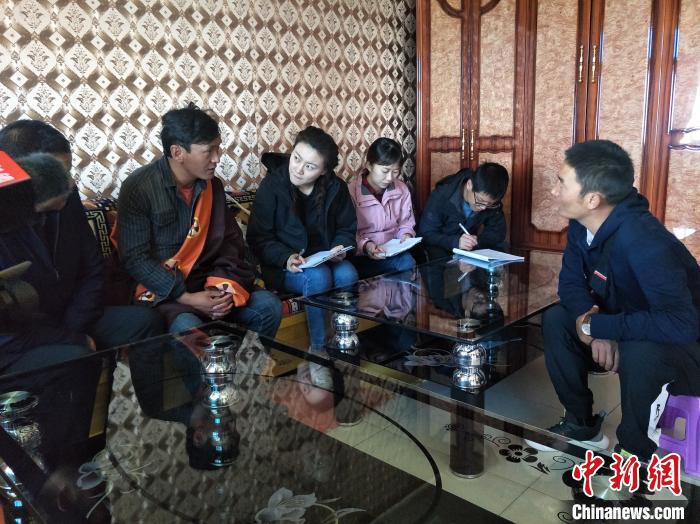 圖為調(diào)查組工作人員正在入戶調(diào)查?！∑钤鲚?攝