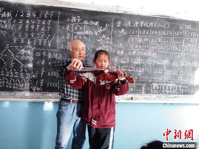 圖為趙興洲教學(xué)生拉小提琴。受訪者提供