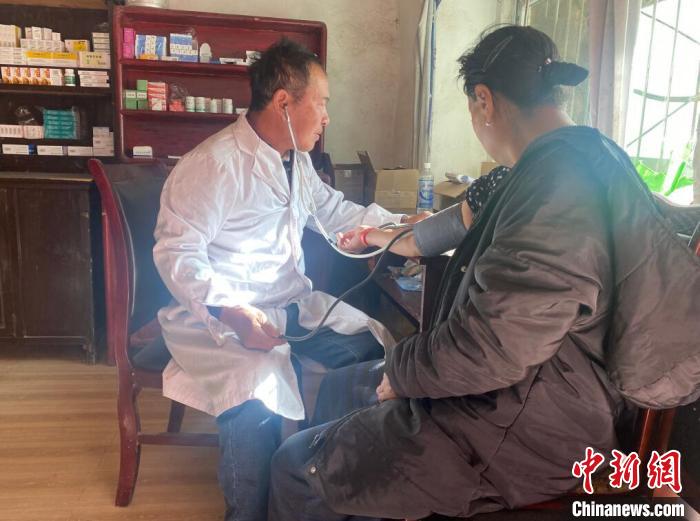 索木滾(左)為村民看病?！∪捞量h委宣傳部供圖
