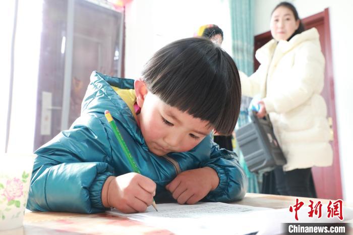孩子們?cè)诩议T口上學(xué)，是楊周馬草搬入蘭州新家最為開心的事情。小女兒楊洋正在學(xué)習(xí)寫數(shù)字?！∥航ㄜ?攝