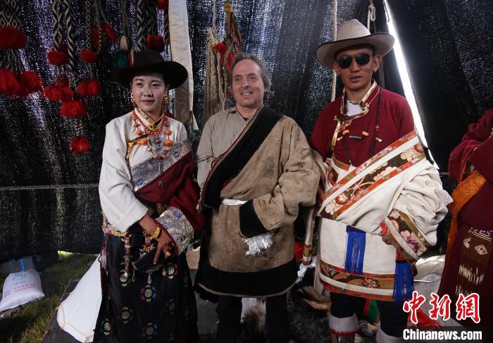 圖為一名外籍攝影師(中)身穿藏服和藏族民眾合影留念?！●R銘言 攝