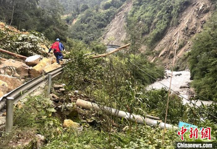 電力搶險人員快速通過危險路段，旁邊是受損的電力線路 四川電力供圖