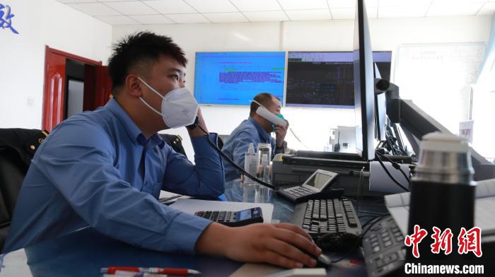 圖為貨運(yùn)調(diào)度人員與外勤工作人員聯(lián)系掌握車輛裝載情況?！±钌?攝