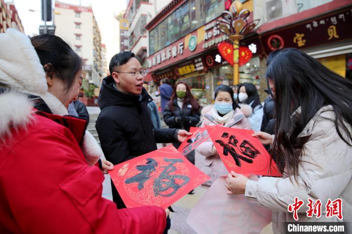 街頭市民收到送的“福”字?！±钣腊?攝