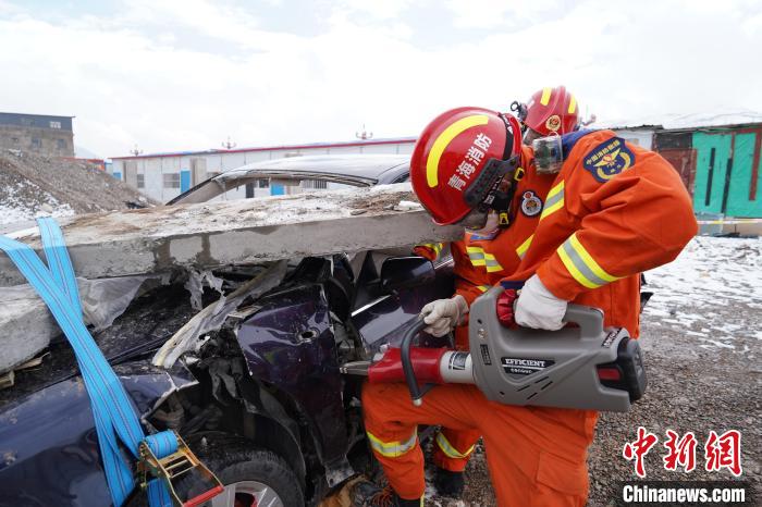 圖為地震實戰(zhàn)拉動現(xiàn)場，參演人員進(jìn)行車輛破拆?！∮駱湎拦﹫D