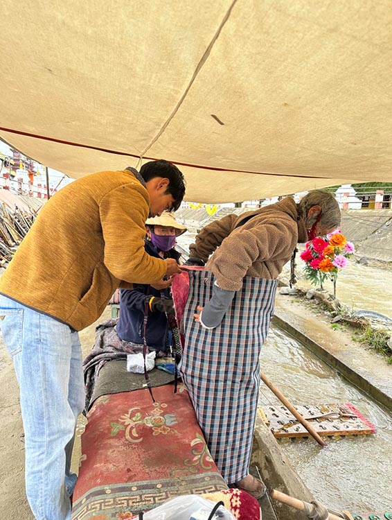 扎西奪爾登為路邊老人送去保暖圍腰。阿壩州文明辦供圖