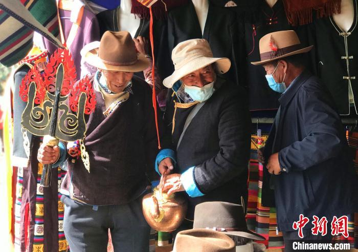 圖為三位藏族老人在集市上聊天交談?！∪轿木?攝