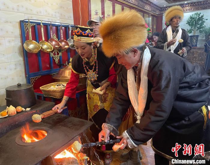 圖為人們?cè)诨鹕峡竟?jié)日美食“結(jié)達(dá)”?！∪轿木?攝