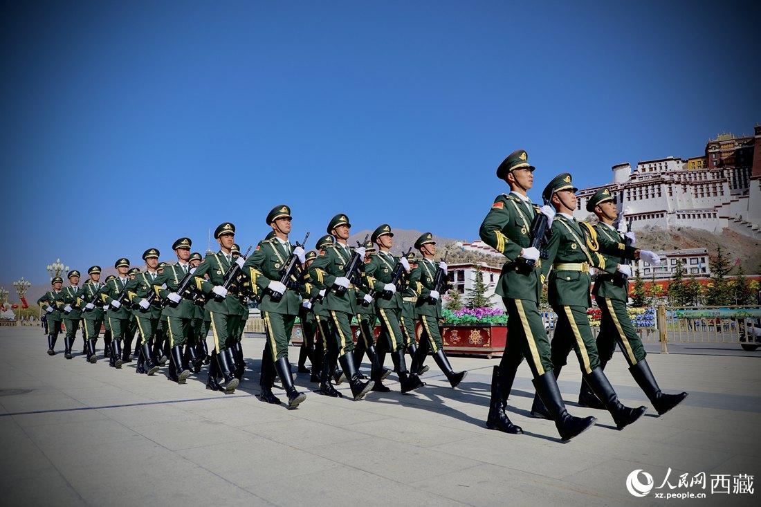 國旗護衛(wèi)隊隊員緊握鋼槍，踏著威武雄壯的步伐，走向國旗臺。人民網(wǎng) 次仁羅布攝