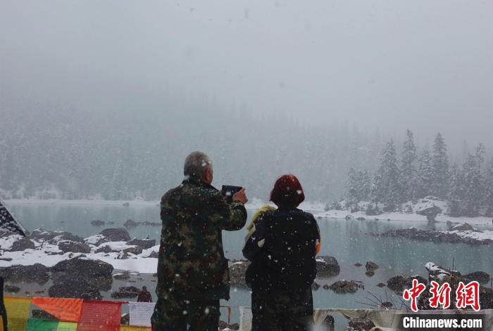 游客欣賞雪中然烏湖。　冉文娟 攝