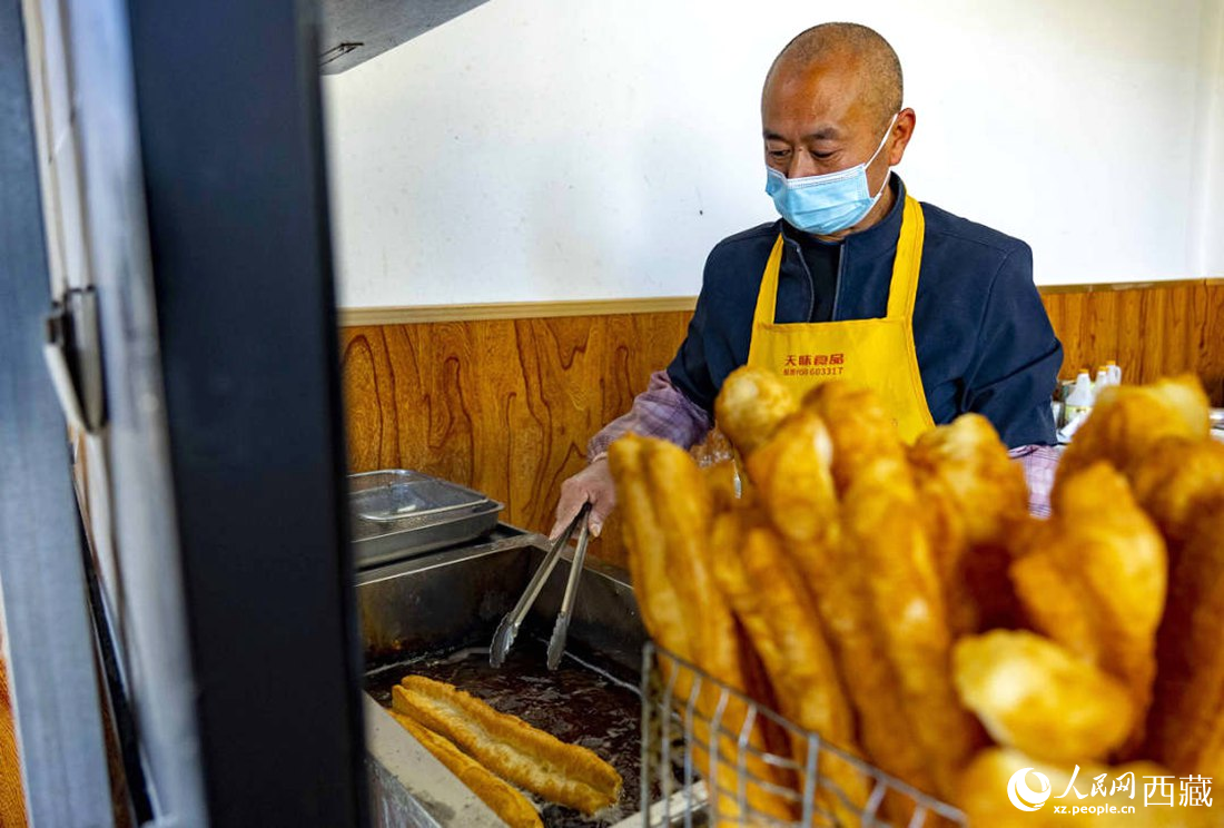 早餐店老板正在炸油條。人民網(wǎng) 次仁羅布攝