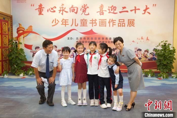 圖為與會嘉賓與入選畫作的“小作者”們在展覽上合影。　中國藏學研究中心供圖