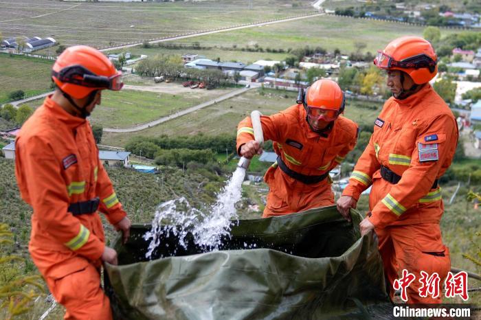 技能大練兵過程中，消防員在陡坡上向蓄水池注水?！±顕鵂c 攝