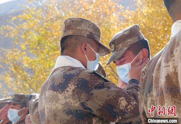 圖為什布奇邊防連退伍老兵與戰(zhàn)友相擁而泣，依依惜別?！⌒觳?攝