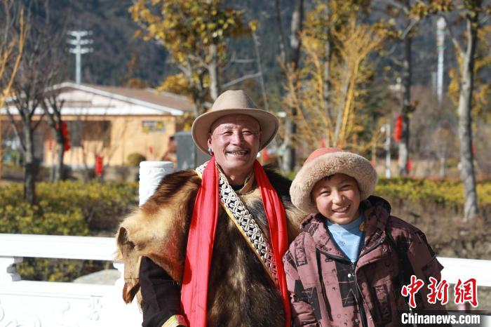 圖為林芝市巴宜區(qū)布久鄉(xiāng)仲果村村民桑杰與孫子一起參加藏歷新年活動?！埩?攝