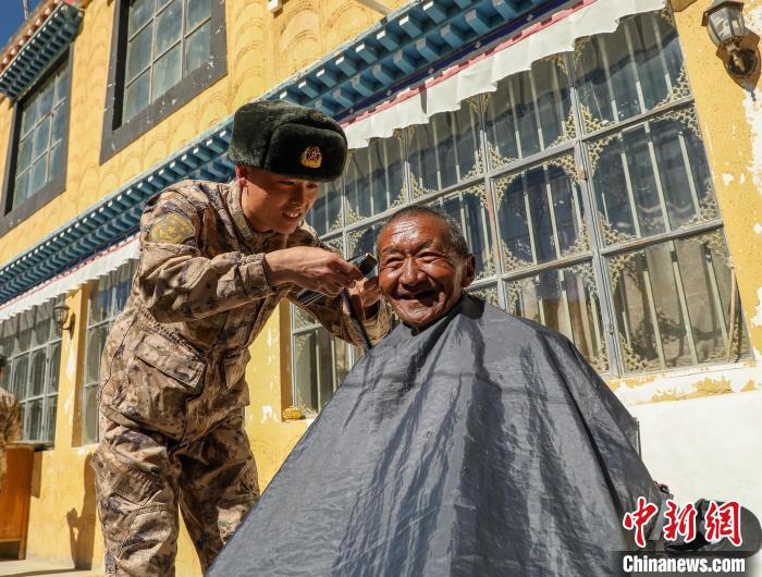 圖為阿里軍分區(qū)某邊防團官兵為駐地群眾理發(fā)迎藏歷新年。　旦增倫珠 攝