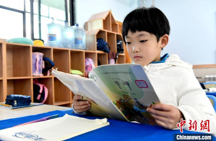 3月14日，西藏拉薩市第一小學一年級六班學生丁增樂吉在閱讀藏語課本。　李林 攝