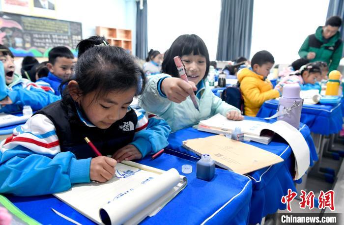 3月14日，西藏拉薩市第一小學一年級六班學生白瑪朗珍(圖左)在藏語文課上書寫藏文?！±盍?攝