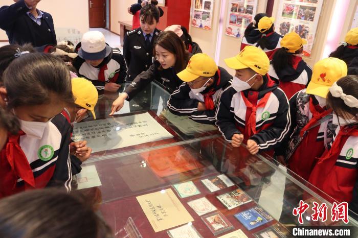 圖為亞東邊檢站民警為駐地小學(xué)生講解該站榮譽(yù)發(fā)展史。　胡利媛 攝