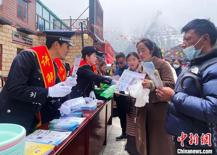 圖為山南玉麥邊境派出所民警為轄區(qū)群眾發(fā)放法律知識宣傳單?！＄婗?　攝
