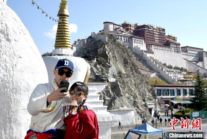 4月17日，游客身著藏式元素服裝在拉薩布達(dá)拉宮觀景臺(tái)拍照留念?！±盍?攝
