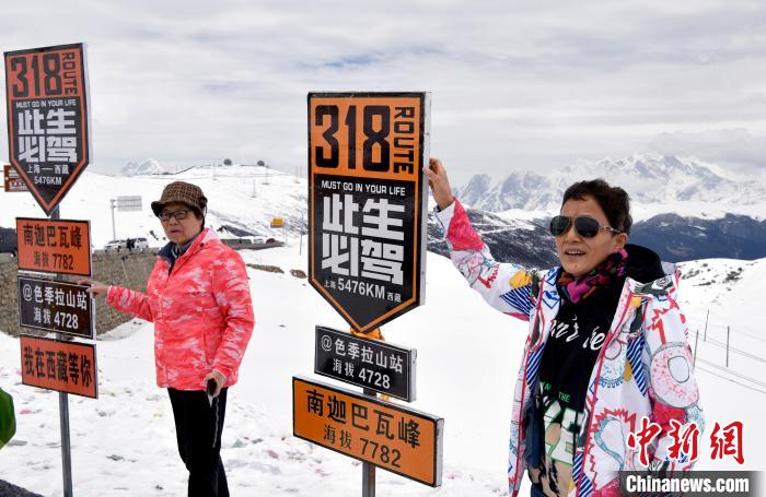 圖為5月14日，西藏林芝色季拉山觀景臺，游客與南迦巴瓦峰合影?！±盍?攝