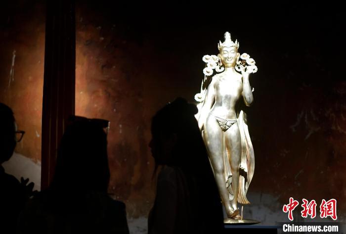 圖為觀眾正在欣賞展覽中的雕塑作品《八萬四千年》?！±盍?攝