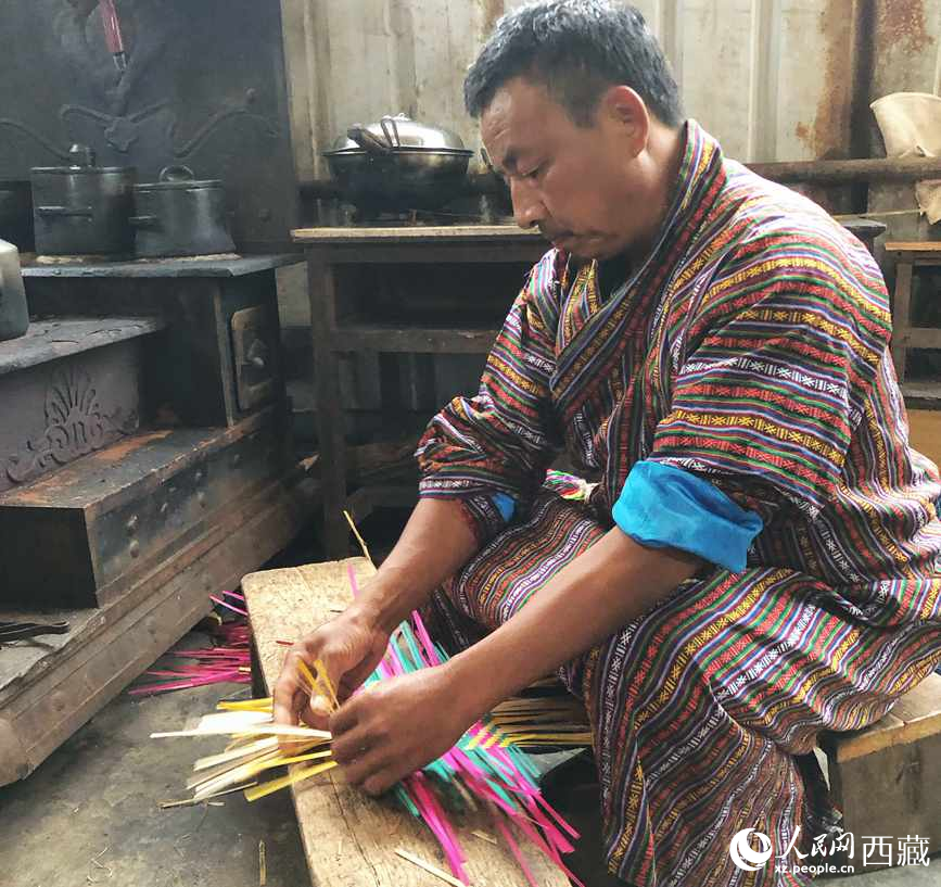 門巴族漢子愛明正在編織藤竹品。