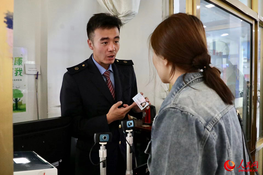 車站工作人員向旅客解答疑問。人民網(wǎng)記者 次仁羅布攝